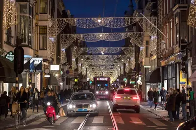 a busy city street with cars and people and christmas lights at Boutique Studio Magielsen in Amsterdam