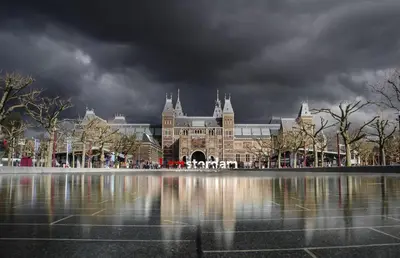 a large building with a reflection in a body of water at Boutique Studio Magielsen in Amsterdam