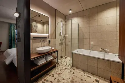 a bathroom with a tub and a sink and a shower at Inntel Hotels Amsterdam Landmark in Amsterdam