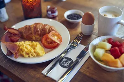 a table with a plate of breakfast food on it at Inntel Hotels Amsterdam Landmark in Amsterdam