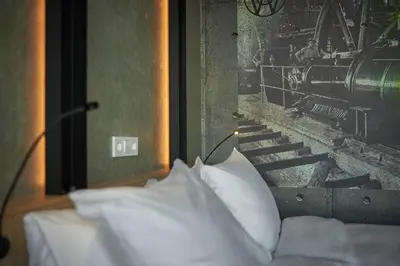 a bed with white pillows and a picture of a train at Inntel Hotels Amsterdam Landmark in Amsterdam