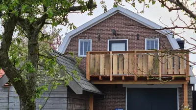a house with a deck on top of it at Vogelzicht in Koedijk