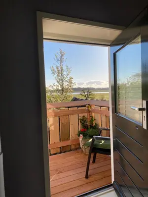 a view from a door of a balcony with a chair at Vogelzicht in Koedijk