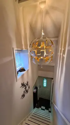 a room with a chandelier and a bed in a room at Vogelzicht in Koedijk