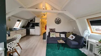 a living room with a couch and a kitchen at Vogelzicht in Koedijk