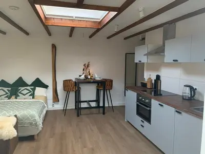 a kitchen with a bed and a table in a room at Cottage 44 - Free parking! in Zandvoort