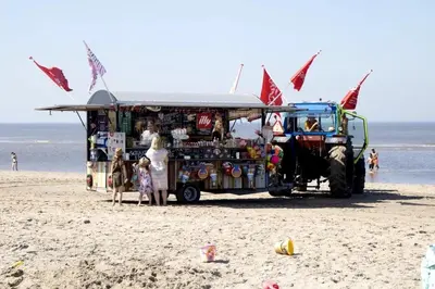 a food truck on the beach with people standing around it at Cottage 44 - Free parking! in Zandvoort