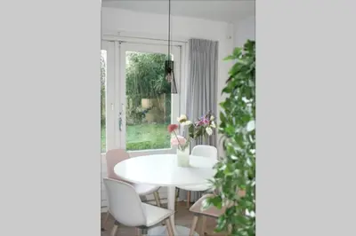 a white dining room with a white table and chairs at Knus familiehuisje nabij Bergen en Schoorl in Warmenhuizen