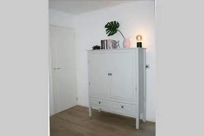 a white cabinet with a plant on top of it at Knus familiehuisje nabij Bergen en Schoorl in Warmenhuizen