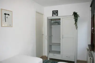a white cabinet in a white room with a bed at Knus familiehuisje nabij Bergen en Schoorl in Warmenhuizen