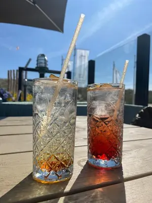 two glasses sitting on top of a wooden table at Knus familiehuisje nabij Bergen en Schoorl in Warmenhuizen