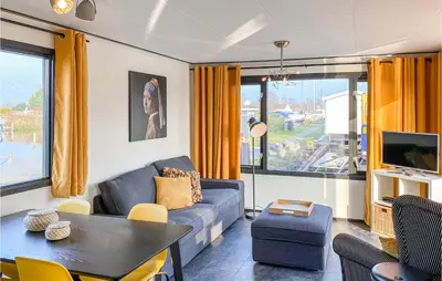 a living room with a couch and a table at Lake Front Home In Breukelen in Breukelen