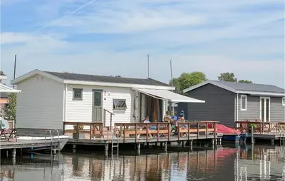 a group of people sitting on a dock next to a house at Lake Front Home In Breukelen in Breukelen