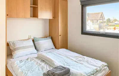 a small bed in a room with a window at Lake Front Home In Breukelen in Breukelen