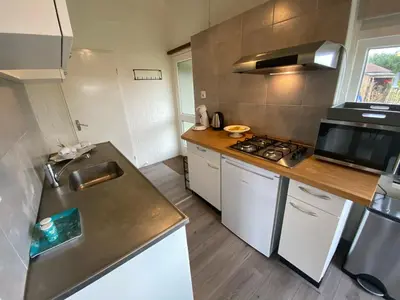 a kitchen with a sink and a stove top oven at Rekerlanden 119 de Amandelbloesem in Schoorldam