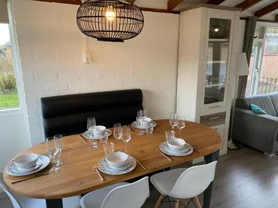 a wooden table with plates and glasses on it at Rekerlanden 119 de Amandelbloesem in Schoorldam