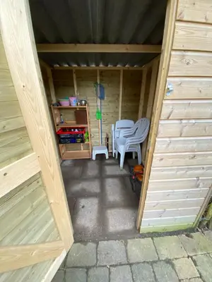 an outside view of a wooden shed with chairs and a table at Rekerlanden 119 de Amandelbloesem in Schoorldam