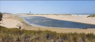 a beach with a body of water with people on it at Rekerlanden 119 de Amandelbloesem in Schoorldam