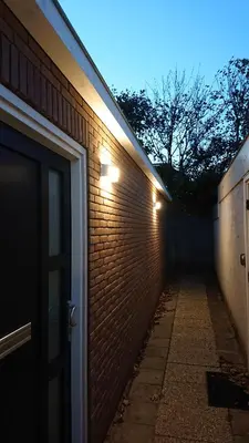 a brick wall with a door and lights on it at Goody in Zandvoort