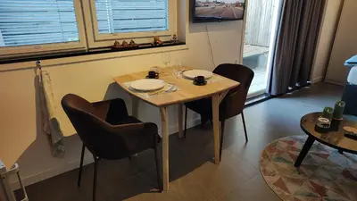 a dining room with a table and chairs and windows at Goody in Zandvoort