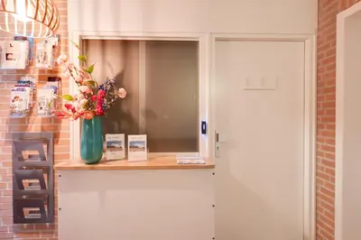 a vase of flowers on a shelf next to a door at DE TRINTEL met zeezicht in Egmond aan Zee