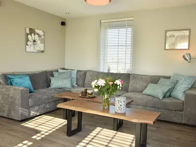 a living room with a couch and a table at Modern holiday home near Schoorl and beach in Schoorldam