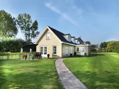 a house with a green lawn in front of it at Modern holiday home near Schoorl and beach in Schoorldam
