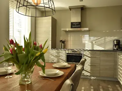 a kitchen with a wooden table with a vase of flowers at Modern holiday home near Schoorl and beach in Schoorldam