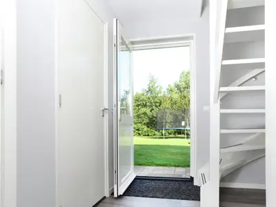 an open door leading to a green yard at Modern holiday home near Schoorl and beach in Schoorldam