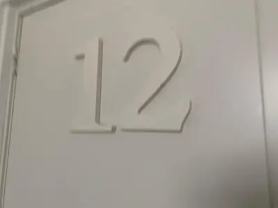 a sign with the number on a white door at Villa Prinsenhof # Twaalf in Bergen