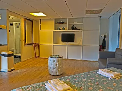 a living room with a couch and a tv at Villa Prinsenhof # Vierendertig in Bergen