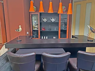 a dining table with chairs and orange vases at Villa Prinsenhof # Vierendertig in Bergen