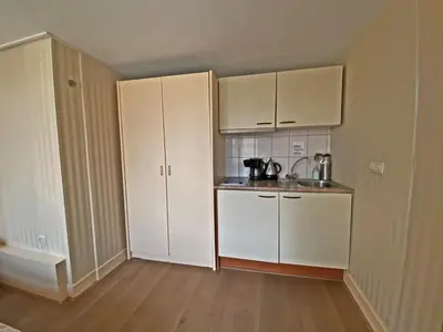 a small kitchen with white cabinets and a sink at Villa Prinsenhof # Vierentwintig in Bergen