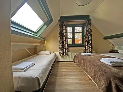 two beds in a room with a window at Villa Prinsenhof # Zes in Bergen