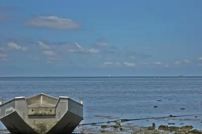 a boat sitting on the shore of the ocean at Villa Prinsenhof # Zes in Bergen