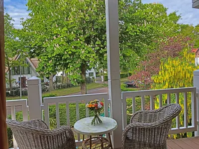 a table with a vase of flowers on a porch at Villa Prinsenhof # Zestien in Bergen