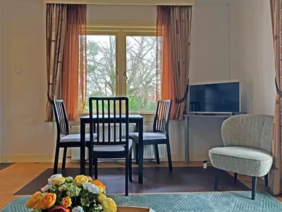 a living room with a table and chairs and a television at Villa Prinsenhof # Zestien in Bergen