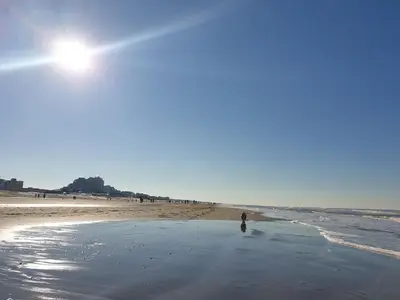 a person standing on a beach with the ocean at Little Lodge Noordwijk aan Zee in Noordwijk