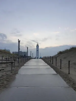 a pathway leading to a lighthouse on the beach at Little Lodge Noordwijk aan Zee in Noordwijk