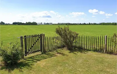 a fence in the middle of a field with a field at Lovely Home In Wijdenes With Wifi in Wijdenes