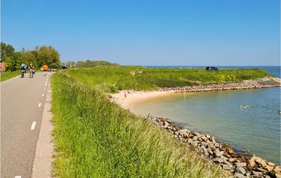 a group of people riding bikes on a road next to a beach at Lovely Home In Wijdenes With Wifi in Wijdenes