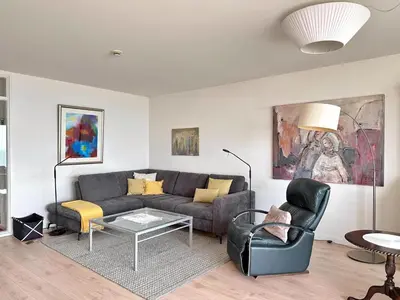 a living room with a couch and a table at Appartementen met uniek zeezicht in Egmond aan Zee
