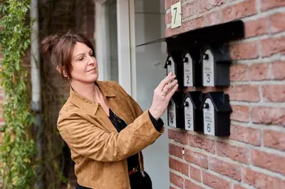 a woman is standing next to a brick wall at B&B Hartje Spakenburg in Spakenburg