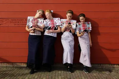 four girls are leaning against a wall holding up their shirts at B&B Hartje Spakenburg in Spakenburg