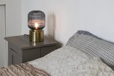 a lamp sitting on a table next to a bed at B&B Hartje Spakenburg in Spakenburg