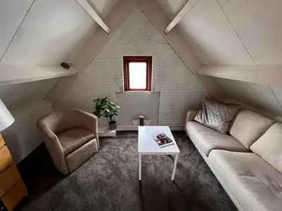a attic living room with a couch and a table at B&B Hartje Spakenburg in Spakenburg