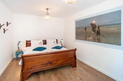 a bedroom with a bed and a painting on the wall at Zee & Zo in Zandvoort