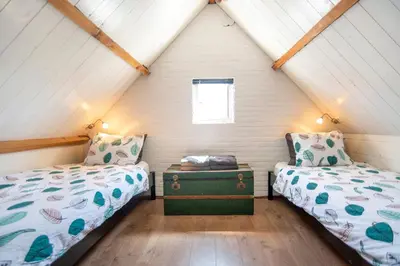a bedroom with two beds and a window at Zee & Zo in Zandvoort