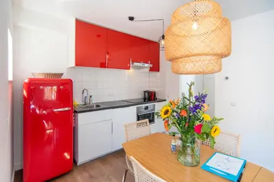 a kitchen with a red refrigerator and a table with flowers at Zee & Zo in Zandvoort