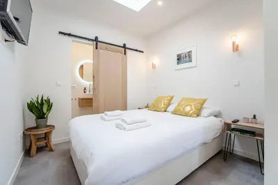 a bedroom with a large white bed with yellow pillows at Beach Studio 35 with private parking in Zandvoort